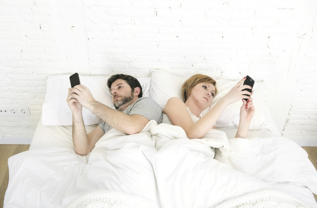 Mobilni telefon, mlad par, krevet