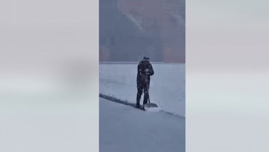 Trener čisti sneg na stadionu